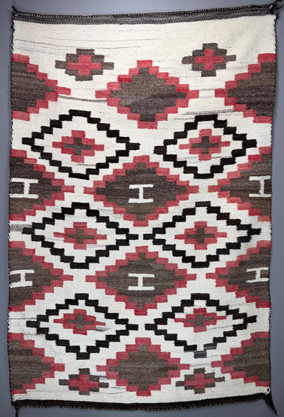 Navajo regional rug featuring a striking all-over geometric diamond composition