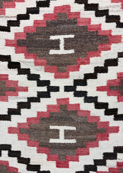 Navajo regional rug featuring a striking all-over geometric diamond composition